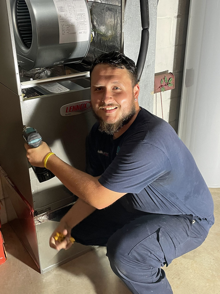 HVAC technician installing an air handler in a commercial space — stock photo, not a Cortez project photo
